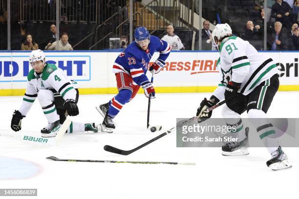 Adam Fox of the New York Rangers shoots the puck to score the game-winning goal as Miro Heiskanen and Tyler Seguin of the Dallas Stars defend during...