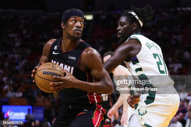 Jimmy Butler of the Miami Heat drives against Jrue Holiday of the Milwaukee Bucks during the second quarter at the Miami-Dade County arena on January...