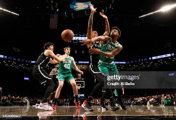 Marcus Smart of the Boston Celtics passes against Nic Claxton of the Brooklyn Nets during their game at Barclays Center on January 12, 2023 in New...