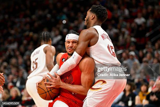 Josh Hart of the Portland Trail Blazers is wrapped up by Donovan Mitchell of the Cleveland Cavaliers in the second quarter at Moda Center on January...