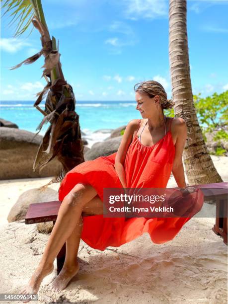 beautiful young woman feels happy and enjoys during summer holidays on a sea tropical beach. - orange dress stock pictures, royalty-free photos & images