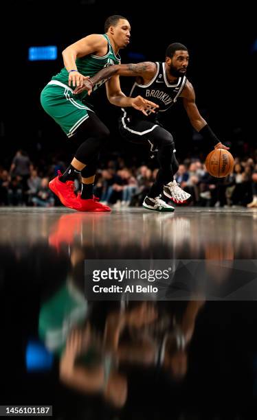 Kyrie Irving of the Brooklyn Nets drives against Grant Williams of the Boston Celtics during their game at Barclays Center on January 12, 2023 in New...