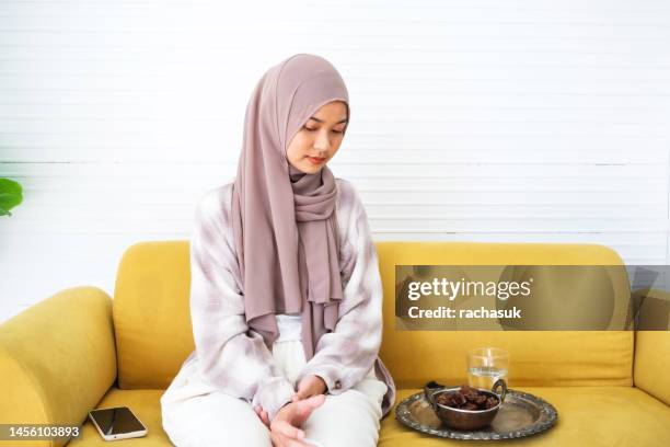 young muslim woman eating date to break fast - fasting stock pictures, royalty-free photos & images