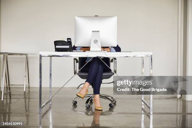 businesswoman sitting behind desktop pc in office - office desk stock pictures, royalty-free photos & images