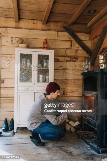 adult man warming himself by the fireplace - buening shack stock pictures, royalty-free photos & images