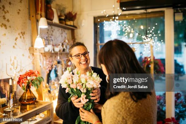 senior florist woman in a flower shop - arranging flowers stock pictures, royalty-free photos & images