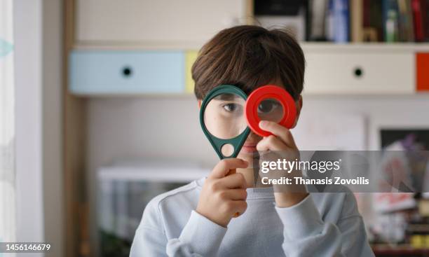 portrait of eleven years old kid boy holding magnifier glass. childhood and discoveries funny concept. - 10 to 13 years stock pictures, royalty-free photos & images