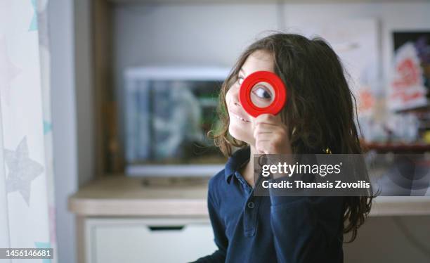 portrait of five years old kid boy holding magnifier glass. childhood and discoveries funny concept. - 4 5 years stock pictures, royalty-free photos & images