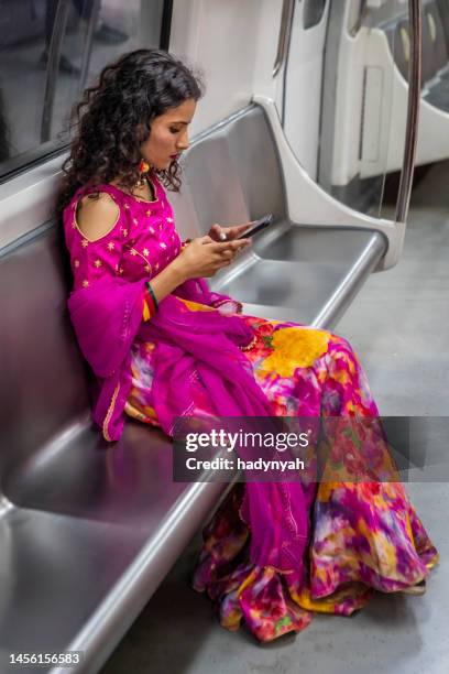 indisches mädchen benutzt ein mobiltelefon in einer u-bahn, indien - india train stock-fotos und bilder