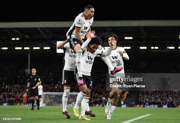 Willian of Fulham celebrates with teammates after scoring their team's first goal during the Premier League match between Fulham FC and Chelsea FC at...