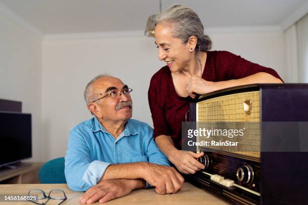 happy senior couple listening radio - radio waves stockfoto's en -beelden