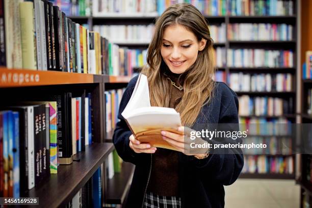 frau liest ein buch in der bibliothek - library　woman stock-fotos und bilder