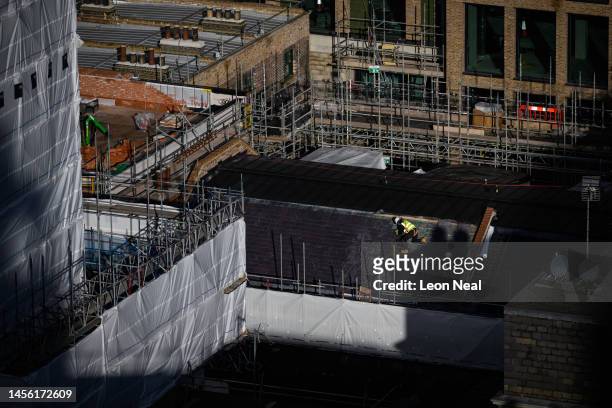 Construction worker is seen as he installs roof tiles on a building site on January 13, 2023 in London, England. The Office For National Statistics...