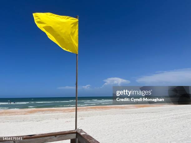 yellow flag showing surf conditions. crescent beach. - life threatening stock pictures, royalty-free photos & images