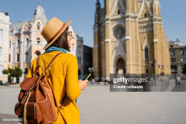 young female tourist looking up directions on a smart phone in novi sad - novi sad stockfoto's en -beelden