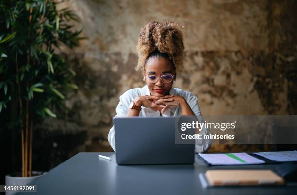 happy businesswoman using a laptop computer in the cafe - african american people stock pictures, royalty-free photos & images