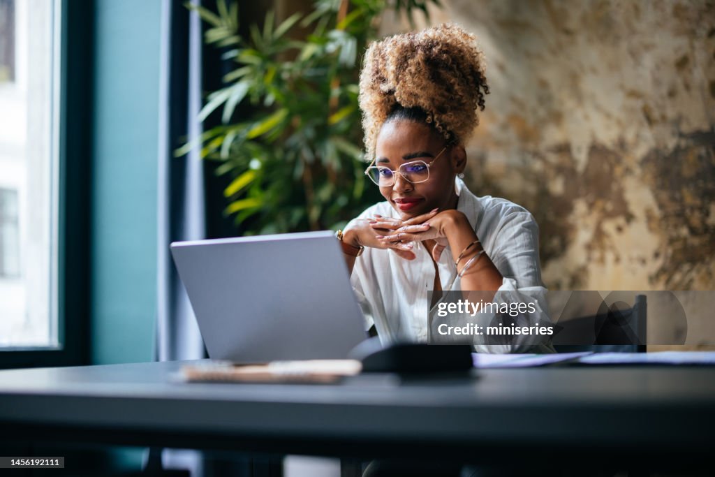 Smiling Businesswoman Using A Laptop Computer In The Cafe
