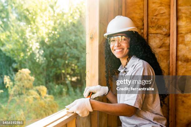 stagiaire en construction travaillant à l’intérieur d’une maison en bois - bâtiment écologique photos et images de collection