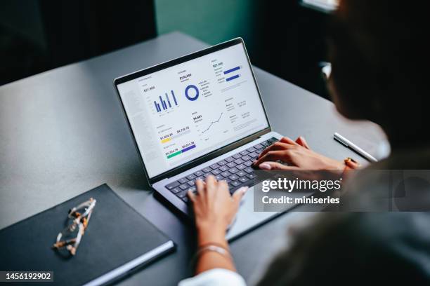 close up photo of woman hands typing business report on a laptop keyboard in the cafe - business analysis stockfoto's en -beelden