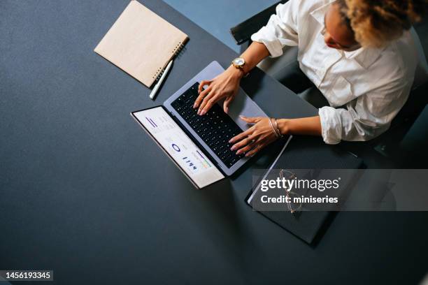 high angle view of unrecognizable woman typing business report on a laptop keyboard in the cafe - desk laptop stockfoto's en -beelden