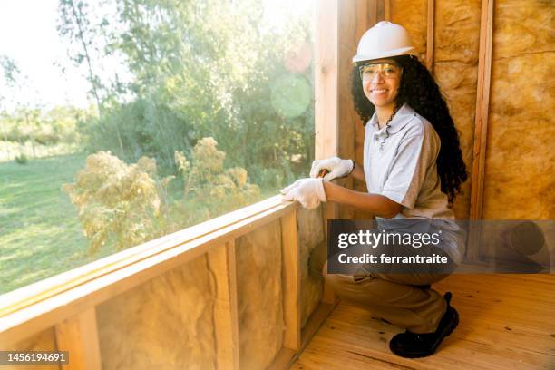 construction trainee working in wooden house interior - house insulation not posing stock pictures, royalty-free photos & images