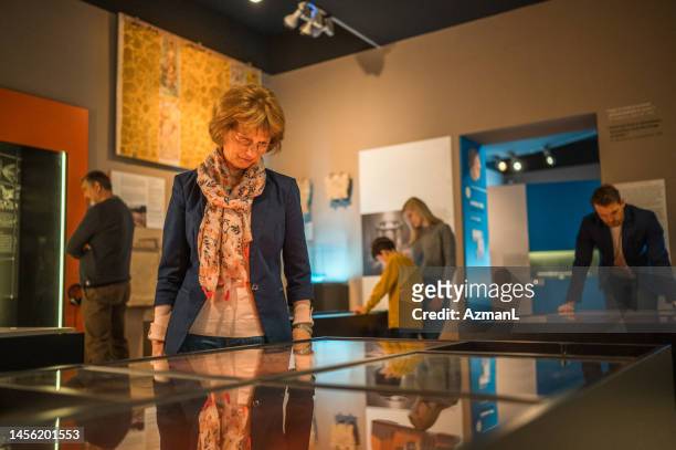 dama mayor en el museo - curator fotografías e imágenes de stock