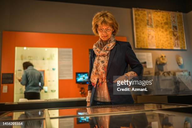 visitante femenina mayor del museo con gafas - curator fotografías e imágenes de stock