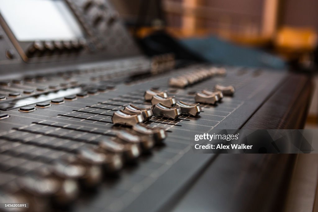 Sound mixing desk with sliders and controls, full frame