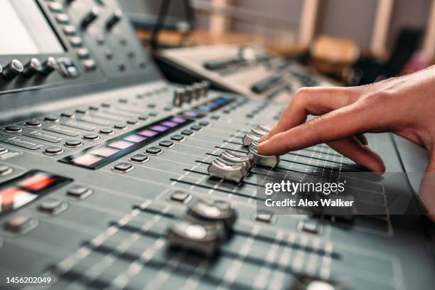 person moving slider on professional sound mixing desk - mixage du son photos et images de collection