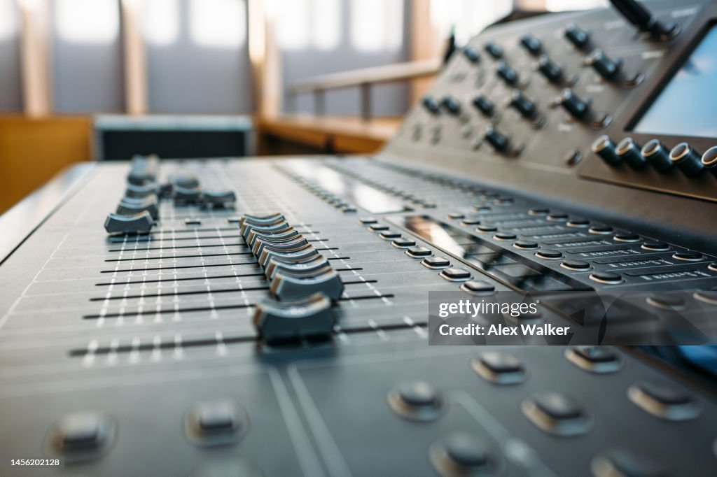 Sound mixing desk with sliders and controls, full frame