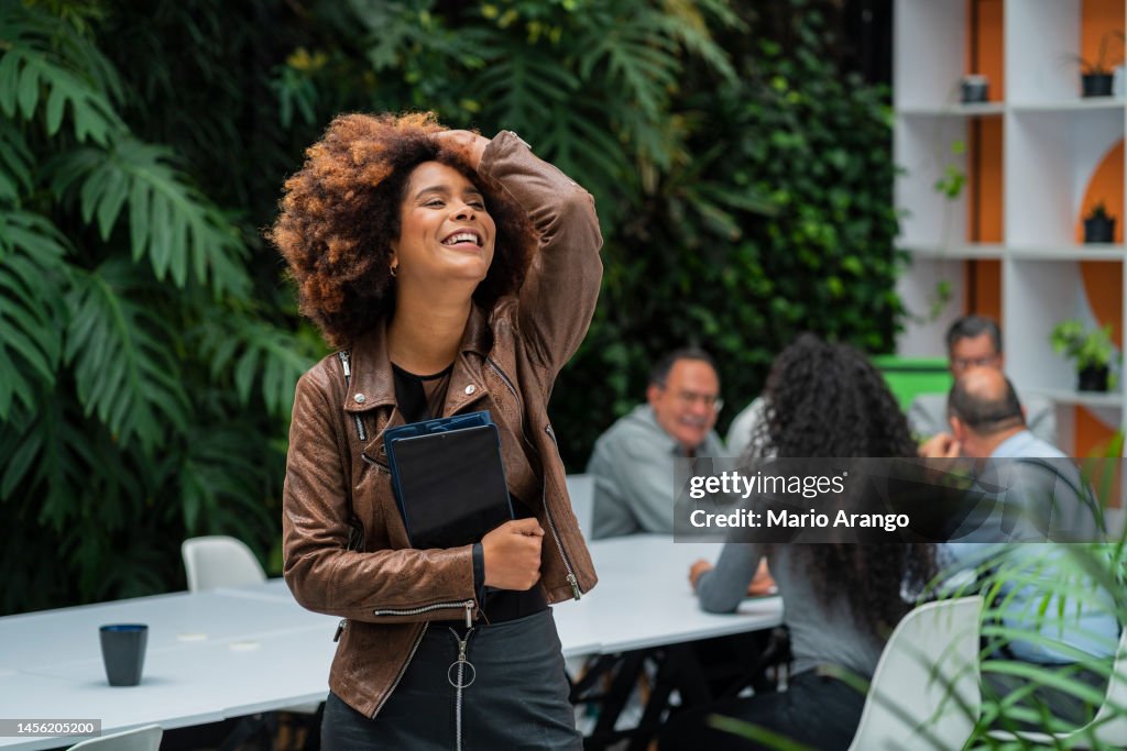 Afrolatin Woman With Long Afro Hair An Employee Of A Large Financial Firm  Is Inside The Company She Works For Photographed While Looking At The  Camera That Portrays Her High-Res Stock Photo -
