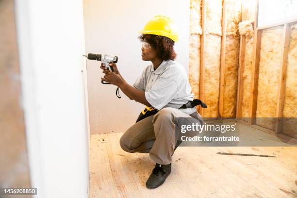 woman installing  drywall - house insulation not posing stockfoto's en -beelden