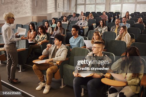 College students listening to their senior teacher on a class at lecture hall.