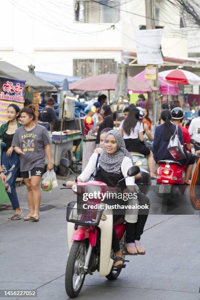 young  thai muslim woman is driving motorcycle - bangkok road stock pictures, royalty-free photos & images