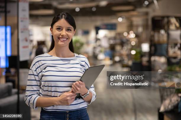 happy retail clerk working at a furniture store - portrait department store stockfoto's en -beelden