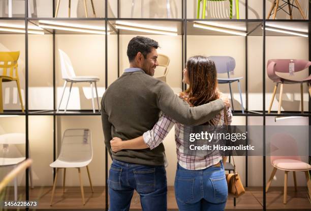 happy couple buying chairs at a furniture store - furniture shop stock pictures, royalty-free photos & images