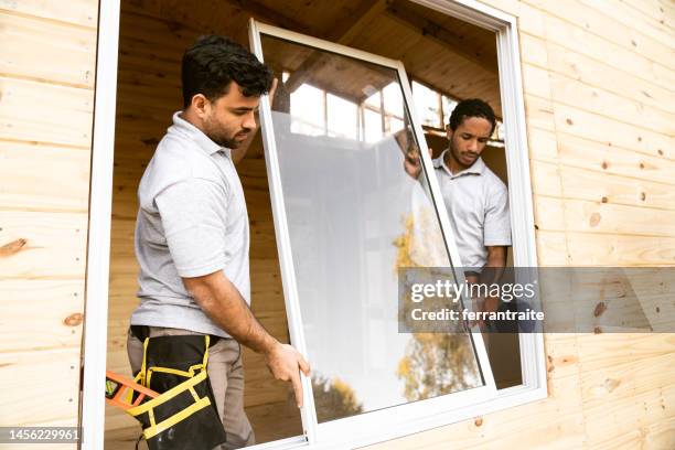 construction workers installing windows - replacement windows stock pictures, royalty-free photos & images
