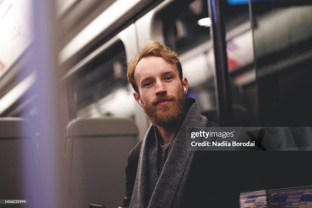 Young beautiful caucasian man commuter in the subway