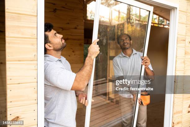 travailleurs de la construction installant des fenêtres - remplacement photos et images de collection