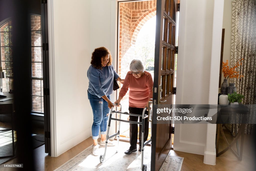 Mid adult woman helps her senior adult friend