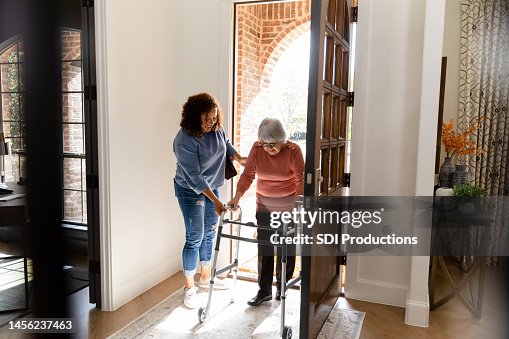 Mid adult woman helps her senior adult friend Mid adult woman helps her senior adult friend