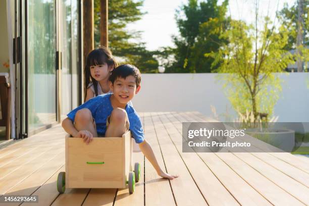 asian brother and sister playing happy together on the balcony at home in the evening the concept of physical affection between siblings . - cardboard car stock pictures, royalty-free photos & images