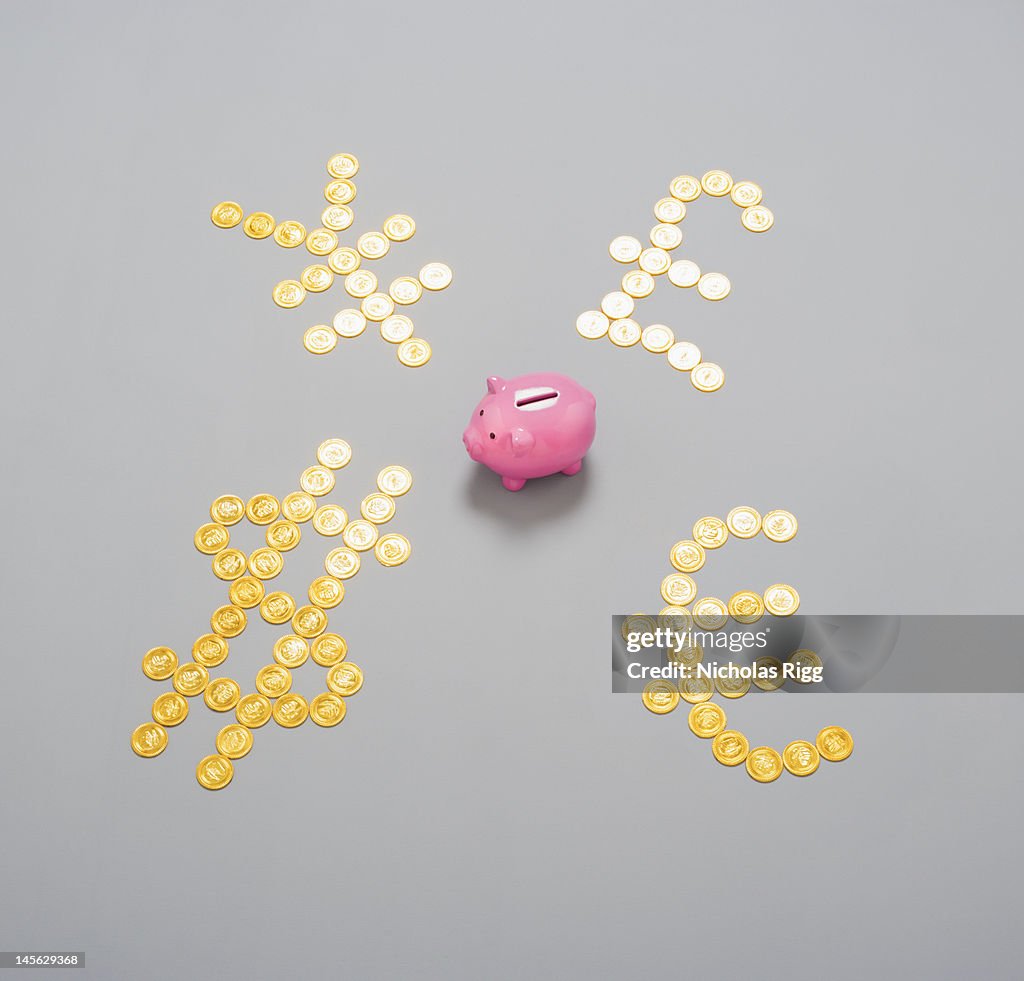 Piggy bank and currency symbols made from coins