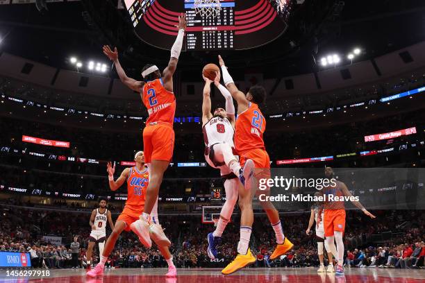 Zach LaVine of the Chicago Bulls shoots over Shai Gilgeous-Alexander and Aaron Wiggins of the Oklahoma City Thunder during the second half at United...