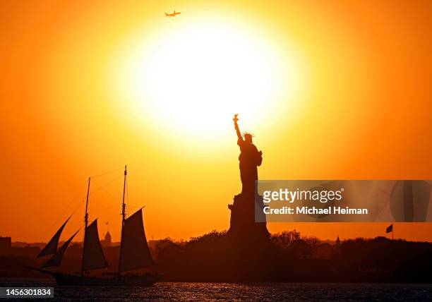 the sunsets behind the statue of liberty - the sun sets behind the statue of liberty stock pictures, royalty-free photos & images