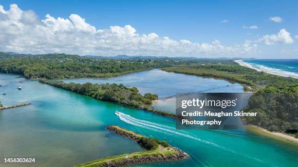 boat driving down an aqua blue river in northern new south wales australia - brunswick heads nsw stock pictures, royalty-free photos & images