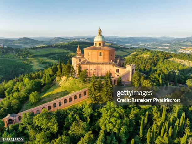 aerial drone sunrise scene of sanctuary of the madonna di san luca chapel existed on the hill for about a thousand years with a road now leads up to the sanctuary, it along a 3.8 km monumental roofed arcade (portico di san luca) consisting of 666 arches - emiglia romana stock-fotos und bilder