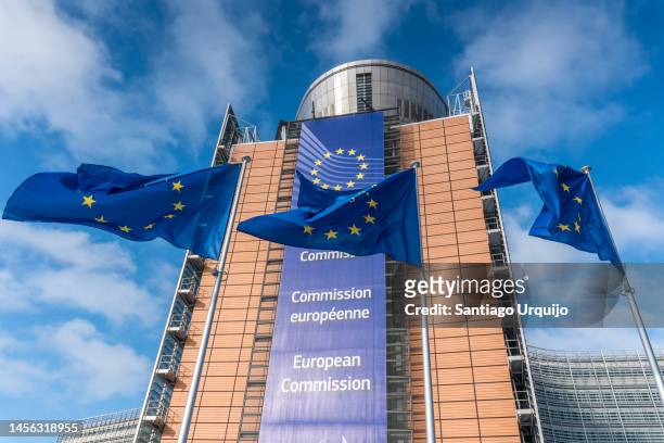 european union flags waiving in front of berlaymont building of the european commission - quartier européen bruxelles photos et images de collection