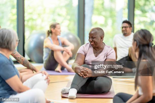 making friends at yoga class - senior yoga lady stock pictures, royalty-free photos & images