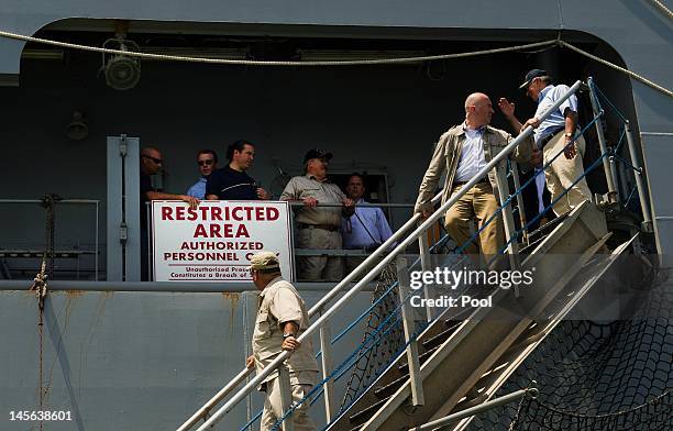 Secretary of Defense Leon Panetta salutes as he walks off the brow while disembarking USNS Byrd after visiting with the crew on June 3, 2012 in Cam...